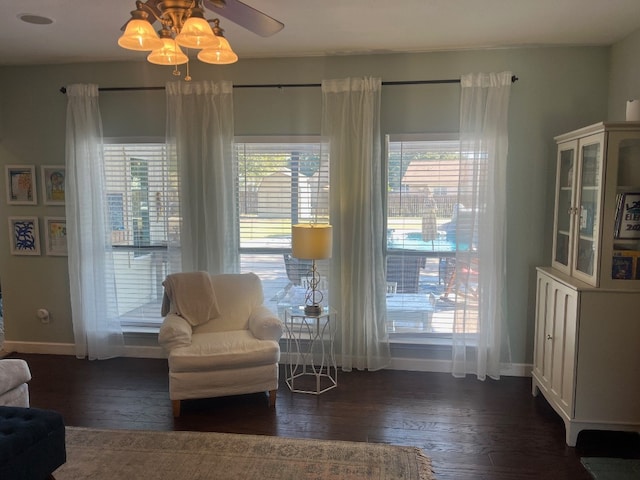 living area with a wealth of natural light, dark hardwood / wood-style floors, and ceiling fan