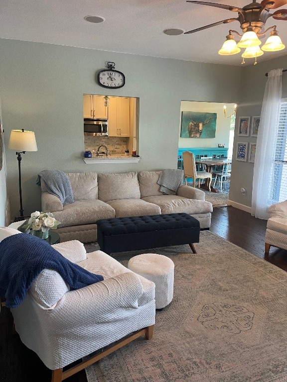 living room featuring dark wood-type flooring and ceiling fan