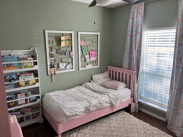 bedroom with dark hardwood / wood-style flooring and ceiling fan