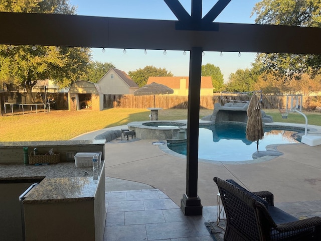 view of pool with an in ground hot tub, a patio, and a lawn