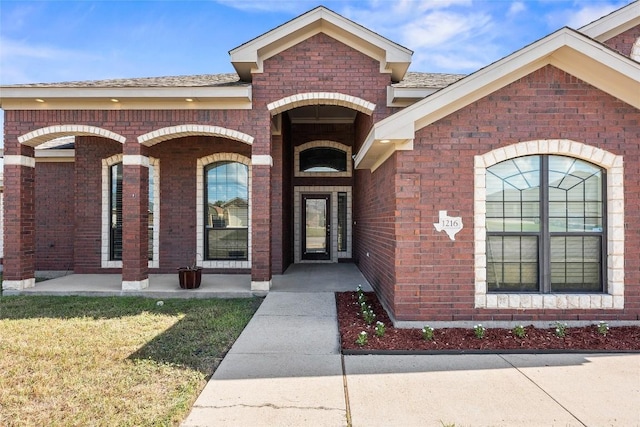 view of exterior entry with a lawn