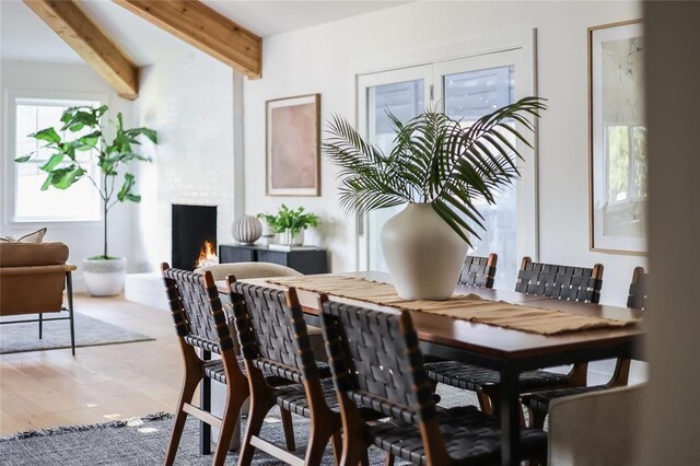 2900 Windsor Rd, Austin, TX 78703 - dining area with beamed ceiling, a fireplace, and wood finished floors