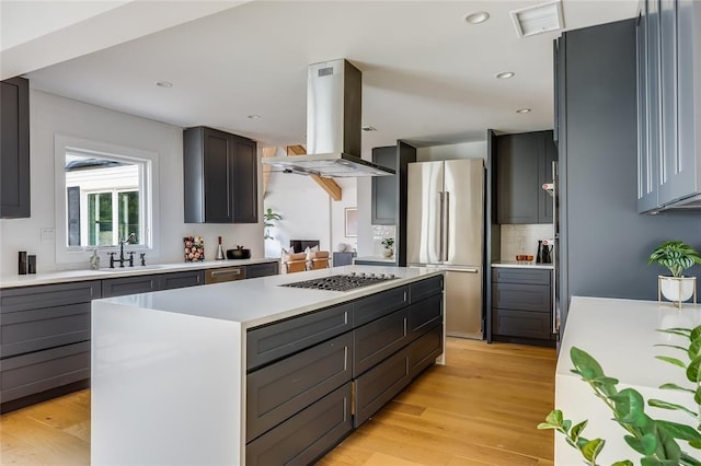 2900 Windsor Rd, Austin, TX 78703 - kitchen with freestanding refrigerator, gas cooktop, a sink, island exhaust hood, and a center island