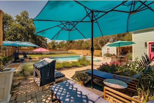 view of patio with a storage shed and a fenced in pool