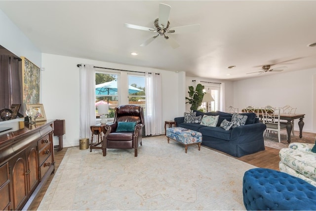 living room with light hardwood / wood-style flooring and ceiling fan