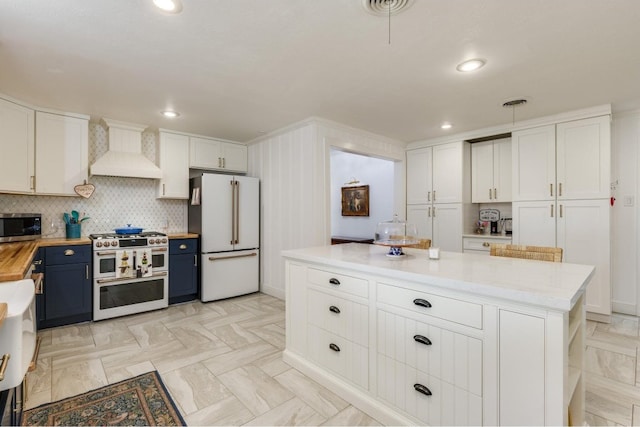 kitchen with white cabinetry, custom range hood, stainless steel appliances, and butcher block countertops