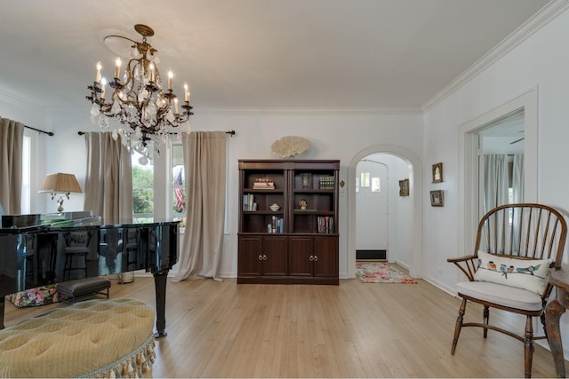 sitting room featuring a notable chandelier, ornamental molding, and light wood-type flooring