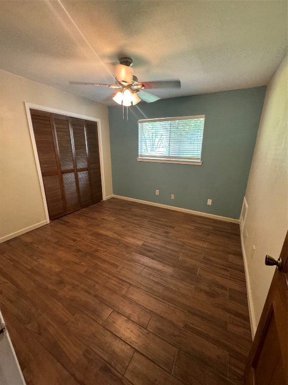 unfurnished bedroom featuring a closet, a textured ceiling, ceiling fan, and dark hardwood / wood-style flooring