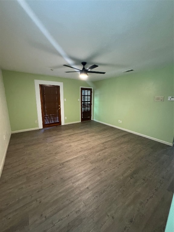 empty room with ceiling fan and dark hardwood / wood-style floors