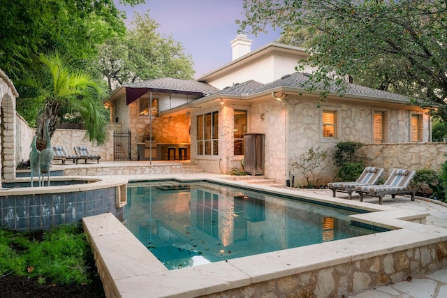 back house at dusk with a patio