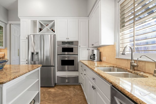 kitchen featuring appliances with stainless steel finishes, a sink, a warming drawer, and open shelves