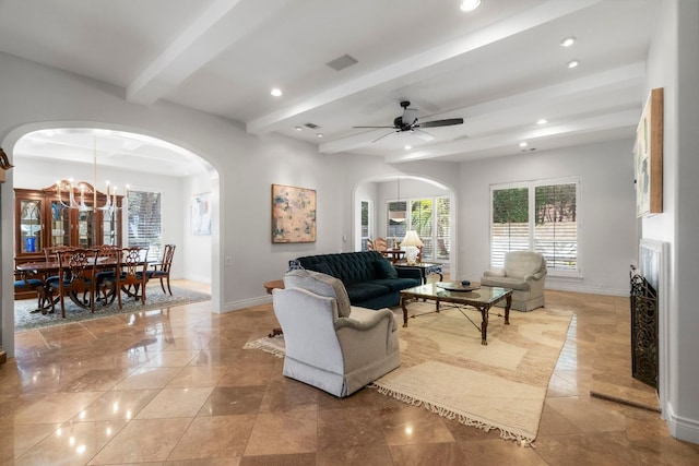 living area featuring baseboards, arched walkways, and beamed ceiling