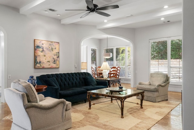 living area with arched walkways, visible vents, beamed ceiling, and recessed lighting