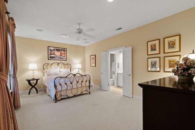 bedroom with light carpet, ensuite bathroom, visible vents, and baseboards