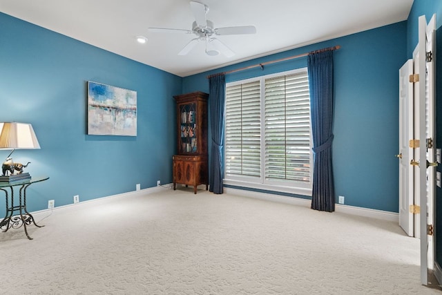 sitting room featuring carpet, a ceiling fan, and baseboards