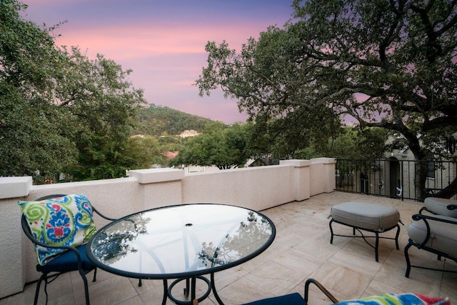 patio terrace at dusk featuring a mountain view