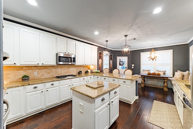 kitchen featuring a center island, white cabinets, decorative light fixtures, kitchen peninsula, and stainless steel appliances