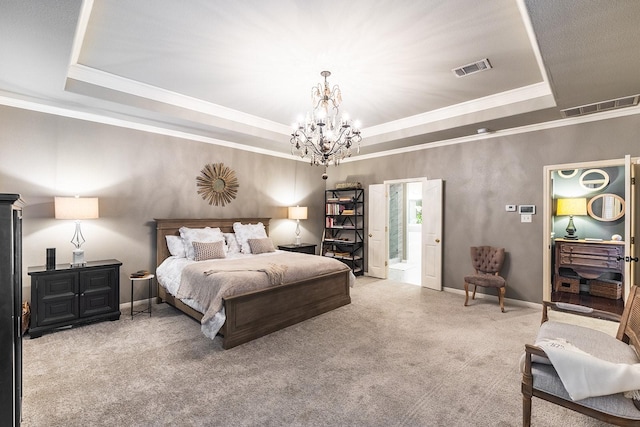 bedroom with ensuite bath, carpet floors, ornamental molding, a chandelier, and a tray ceiling