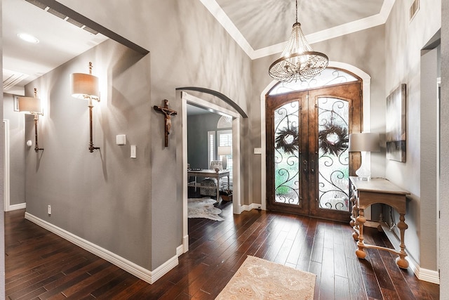 entryway with dark hardwood / wood-style floors, french doors, and an inviting chandelier