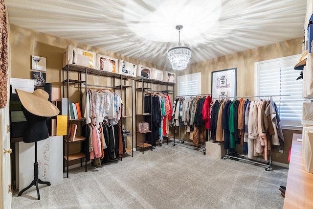 walk in closet with light colored carpet and an inviting chandelier