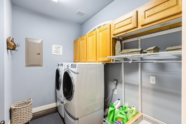 clothes washing area with electric panel, cabinets, and washing machine and dryer