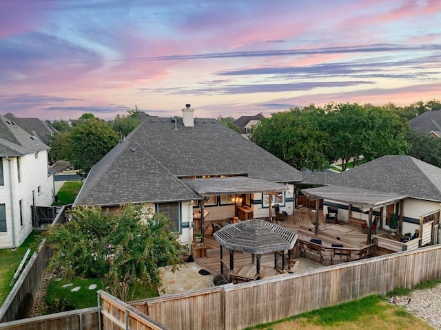 back house at dusk with a patio area