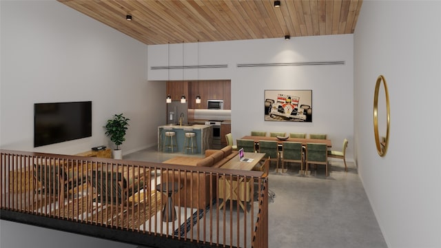 living room featuring concrete flooring, wooden ceiling, and sink