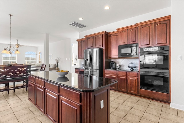 kitchen featuring a kitchen island, hanging light fixtures, backsplash, black appliances, and light tile patterned floors