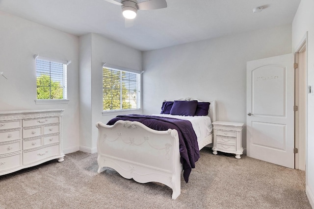 carpeted bedroom featuring ceiling fan and multiple windows