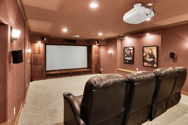 cinema room with ornamental molding and carpet