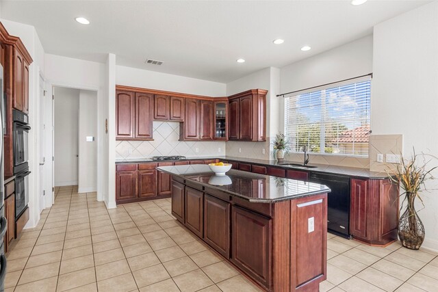 kitchen featuring decorative backsplash, sink, black appliances, a center island, and light tile patterned flooring