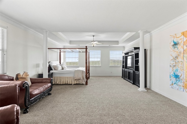 carpeted bedroom featuring ornate columns, ceiling fan, crown molding, and a tray ceiling