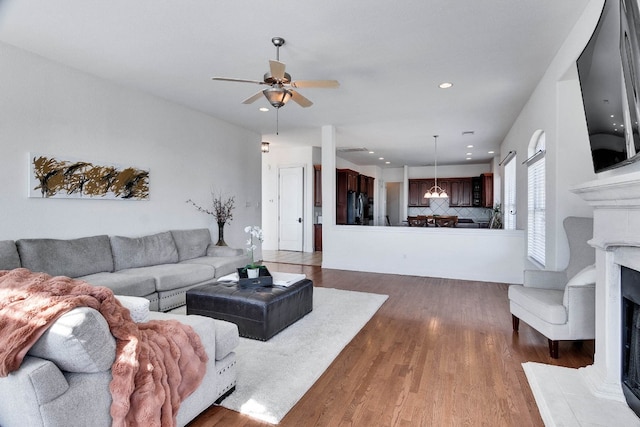 living room featuring dark wood-type flooring and ceiling fan