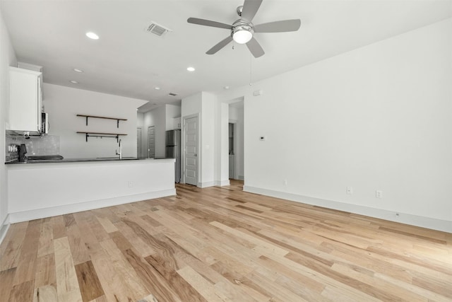 unfurnished living room featuring light wood-type flooring and ceiling fan