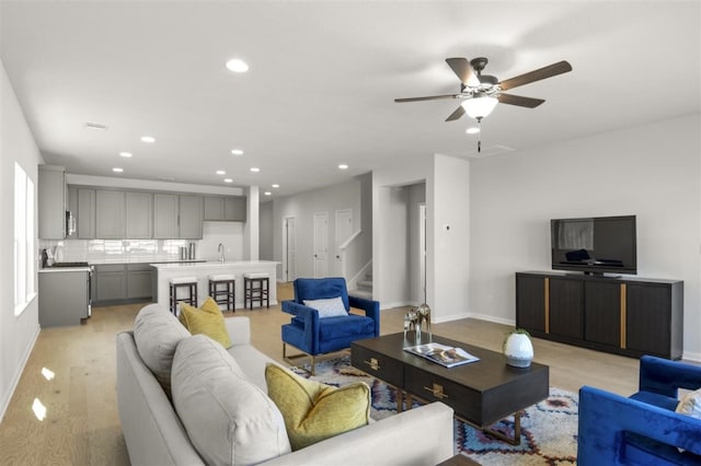 living room with light hardwood / wood-style floors and ceiling fan