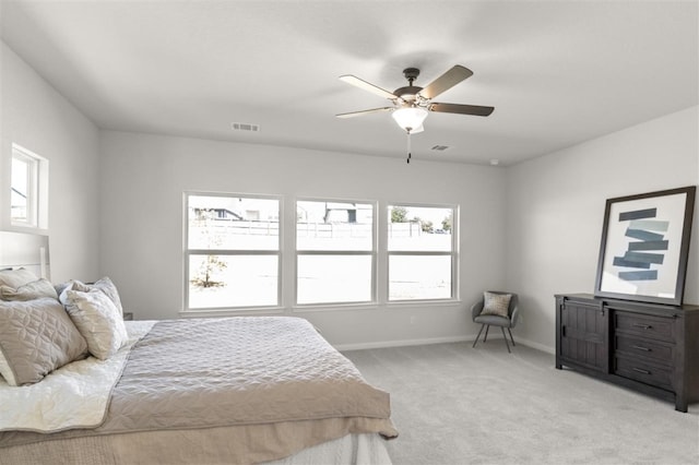 bedroom featuring multiple windows, light colored carpet, and ceiling fan