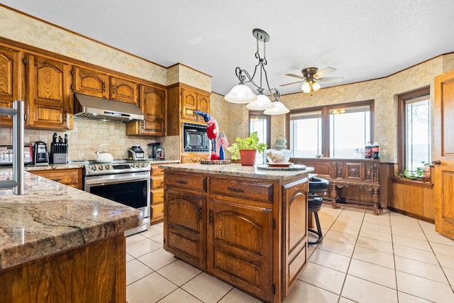 kitchen featuring a kitchen island, electric stove, pendant lighting, light stone counters, and black microwave