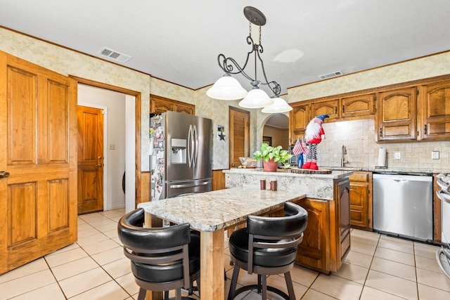 kitchen featuring appliances with stainless steel finishes, a center island, and hanging light fixtures