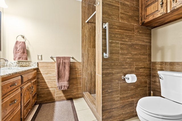 bathroom with vanity, tile patterned floors, toilet, and an enclosed shower