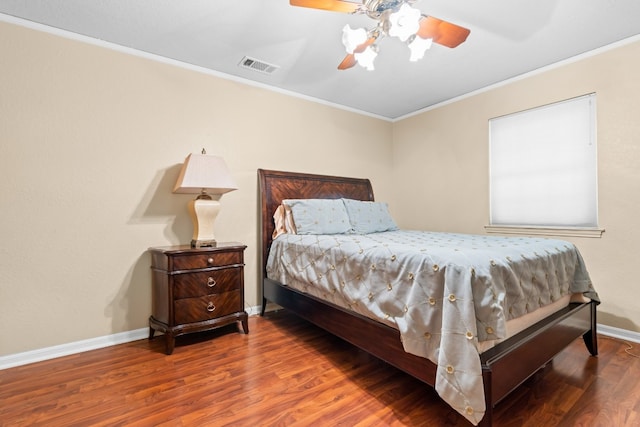 bedroom with dark hardwood / wood-style flooring, ornamental molding, and ceiling fan