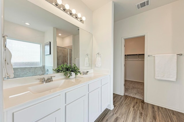 bathroom featuring hardwood / wood-style flooring, vanity, and an enclosed shower