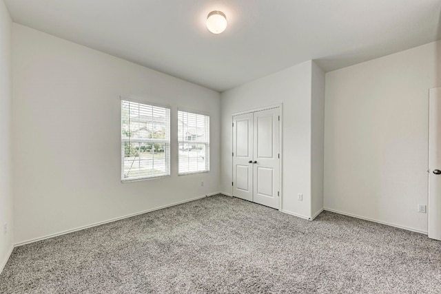 unfurnished bedroom featuring light carpet and a closet