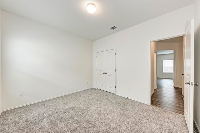 unfurnished bedroom featuring a closet and hardwood / wood-style floors