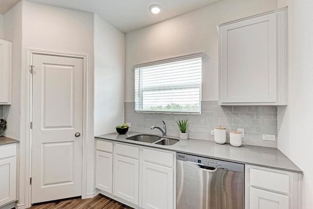 kitchen with dishwasher, sink, hardwood / wood-style floors, decorative backsplash, and white cabinets