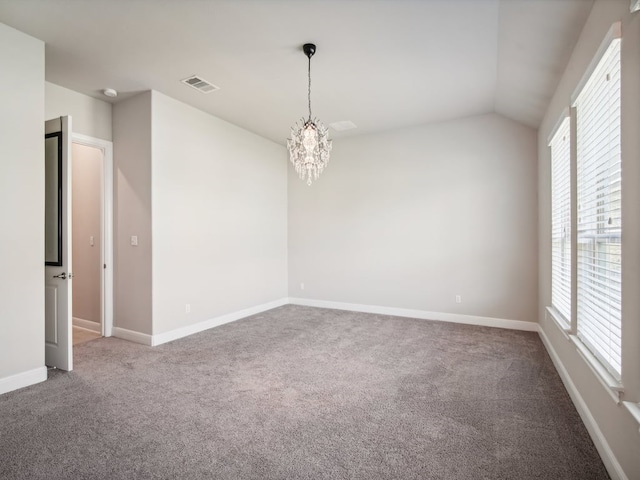 spare room with carpet flooring, a notable chandelier, and lofted ceiling