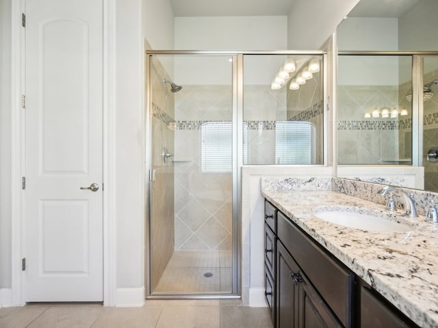 bathroom featuring vanity, tile patterned floors, and a shower with shower door