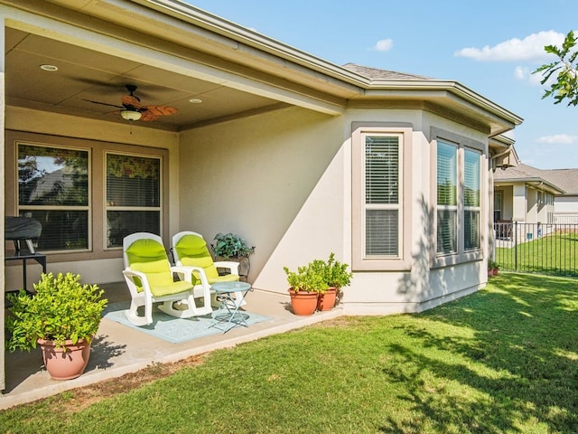 exterior space with ceiling fan and a lawn