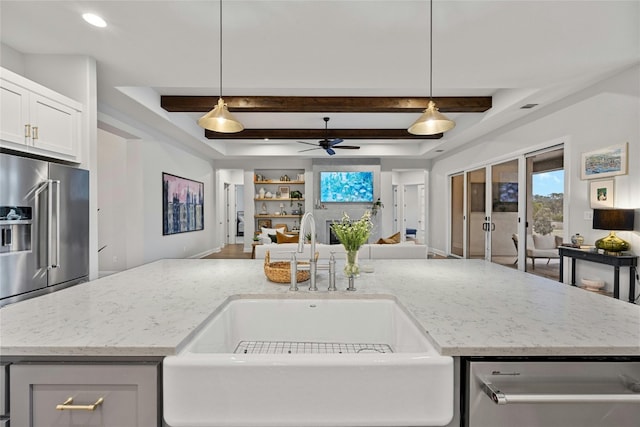 kitchen featuring a center island with sink, stainless steel appliances, sink, and pendant lighting