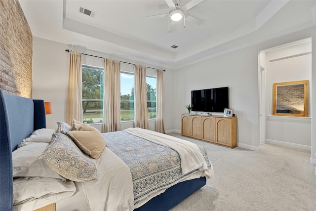 bedroom with ceiling fan, a raised ceiling, ornamental molding, and light colored carpet