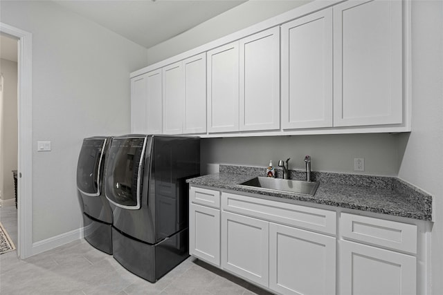 laundry room with sink, light tile patterned floors, cabinets, and washer and clothes dryer